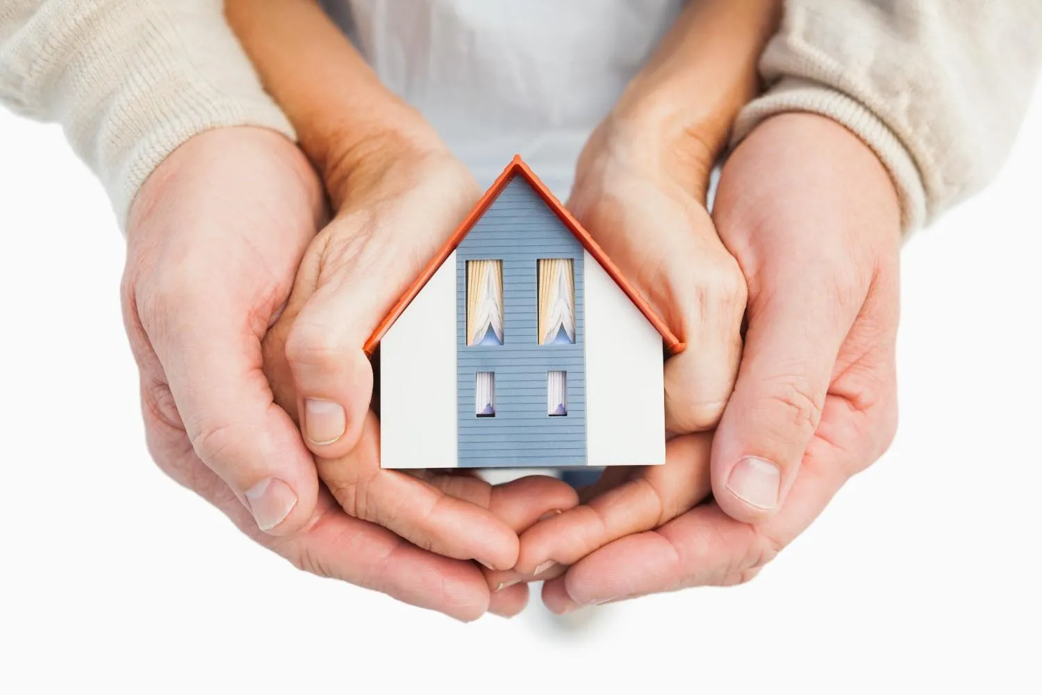 A small wooden house model placed beside a coverage checklist.